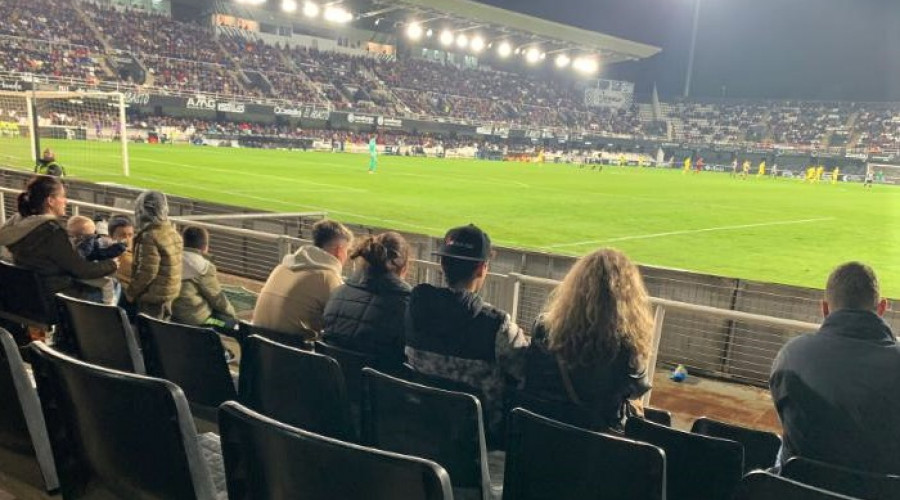 Los tres jóvenes y una de las orientadoras, en las gradas durante el partido